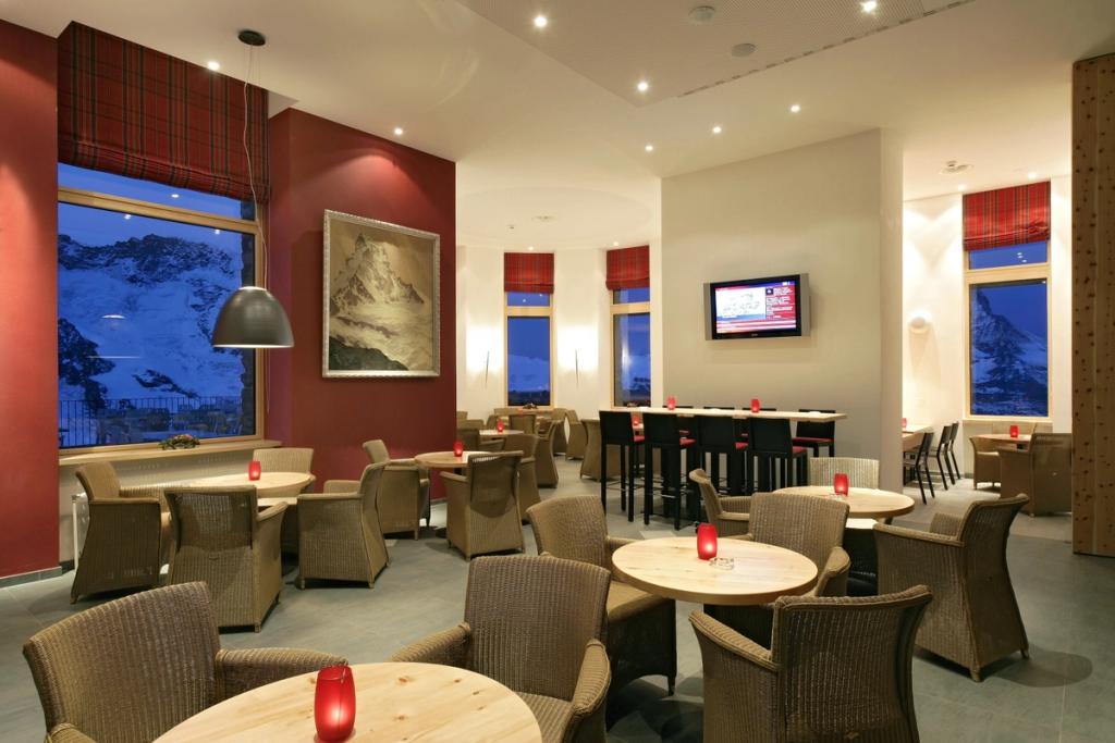 The hotel café with a painting of the Matterhorn and windows overlooking the snow-capped Alpine summits