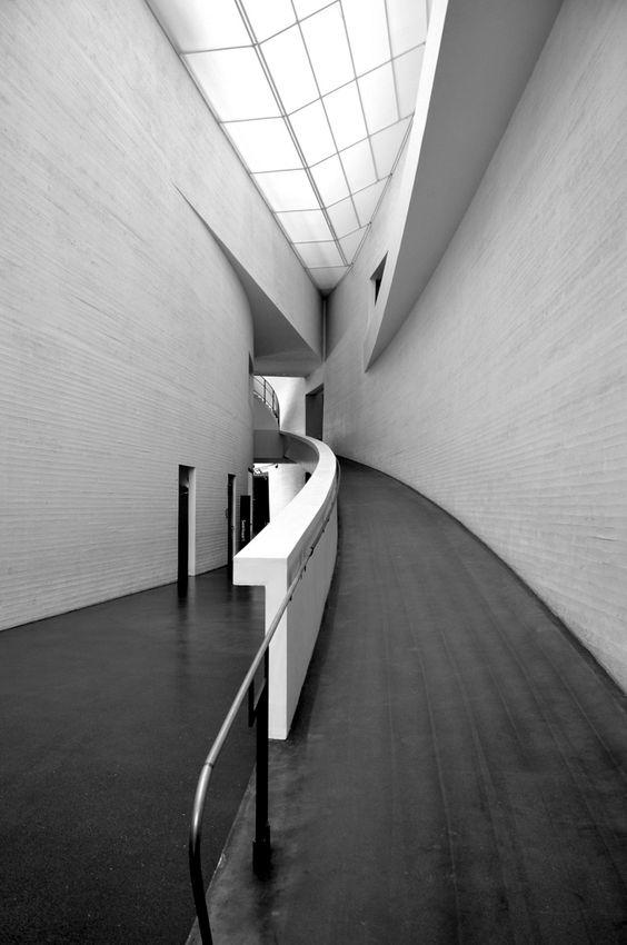 Чёрно-белый интерьер музея Kiasma с изогнутым пандусом под световым фонарём, Хельсинки