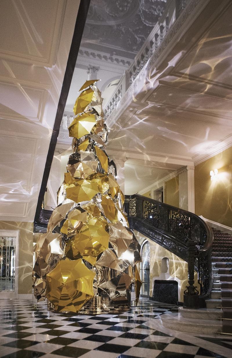 A tree of inverted golden umbrellas beneath the hotel's high ceiling