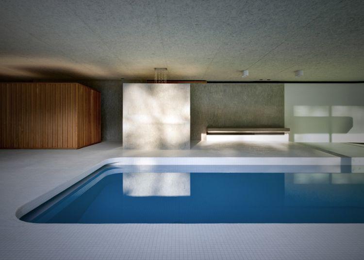 Крытый бассейн La Piscina del Roccolo с деревянной панелью и бетонной перегородкой
