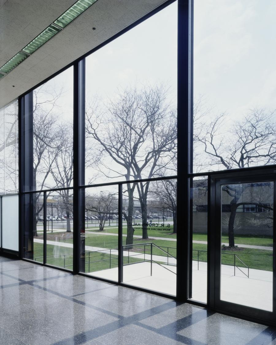 View from inside Crown Hall of bare trees through the glass wall with steel mullions