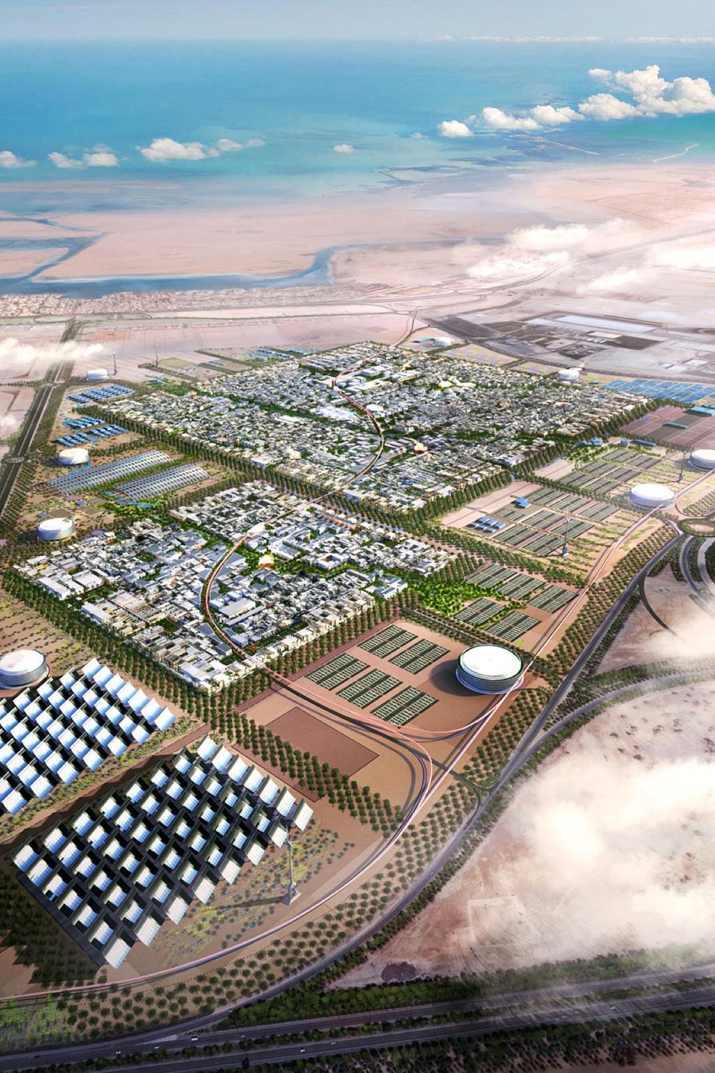 Aerial photograph of the Masdar City eco-city project in the desert, with solar panel fields by the sea