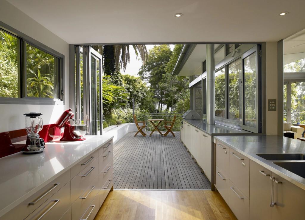 A bright kitchen with sliding glass walls opening onto the terrace