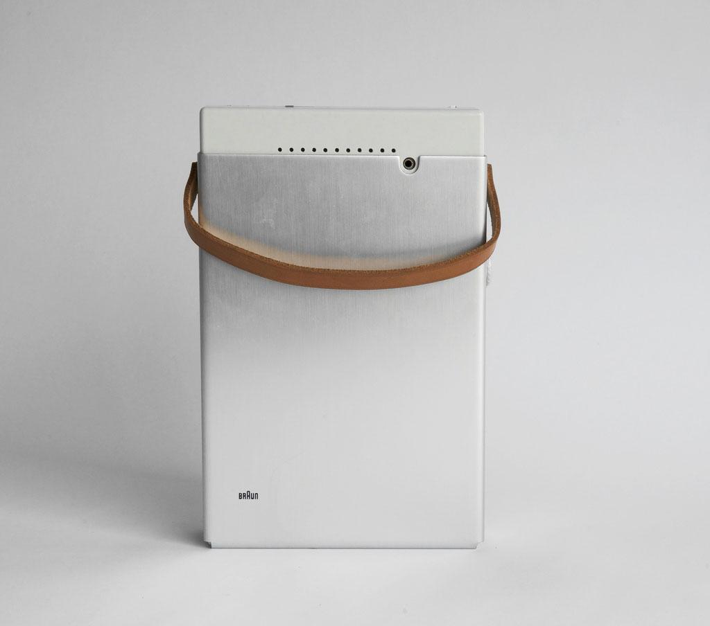 Braun wristwatch with a white dial and steel mesh bracelet, next to a booklet