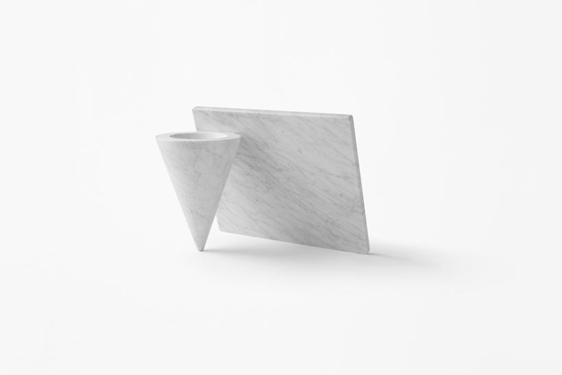 A white marble stand with a cone and an angled slab