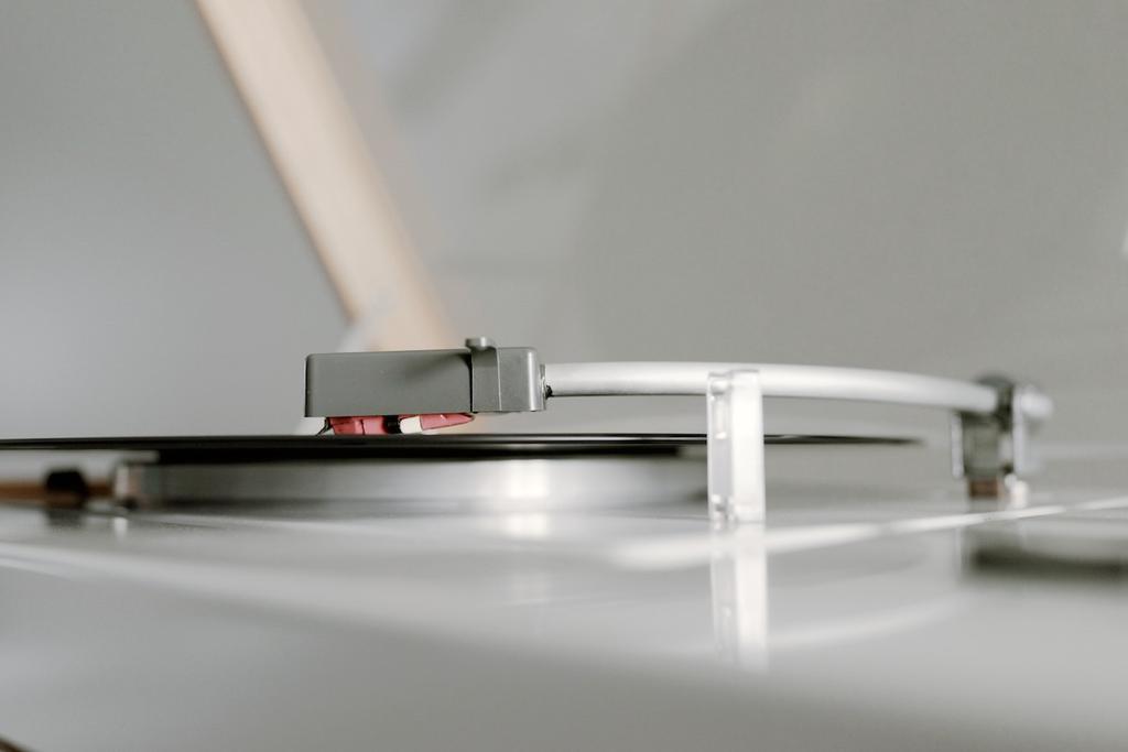 Close-up of the cartridge head and tonearm poised above the edge of a vinyl record