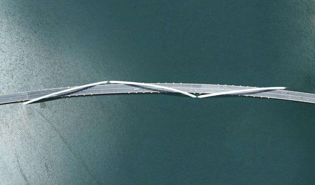 The Juscelino Kubitschek Bridge from above: white crossing arches over dark water