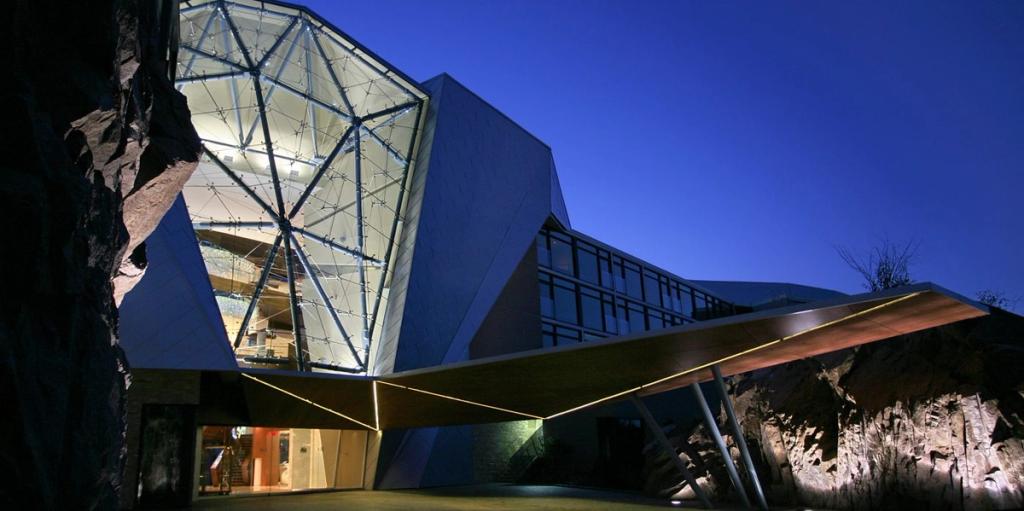 The glass entrance façade of Sparkling Hill Resort illuminated in the blue twilight