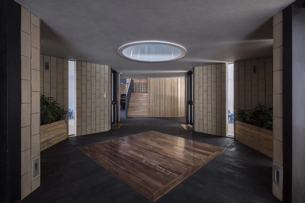 The entrance hall of Walden Dos School, with a circular rooflight and dark wooden floor