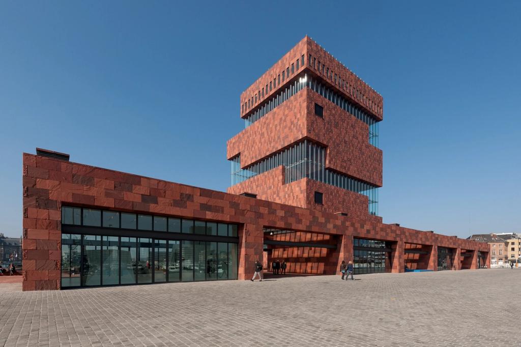Башня Museum aan de Stroom из красного песчаника на площади под синим небом, Антверпен