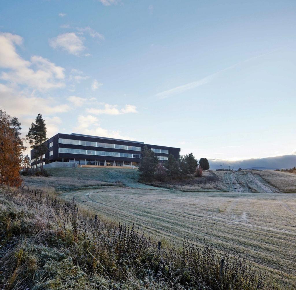 Nord-Osterdal school: a long dark building on a hill above a frost-covered field