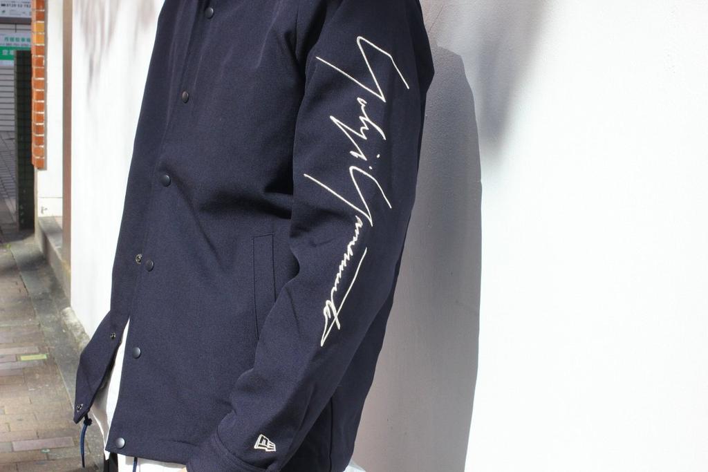 A dark navy New Era jacket with an embroidered Yohji Yamamoto signature on the sleeve