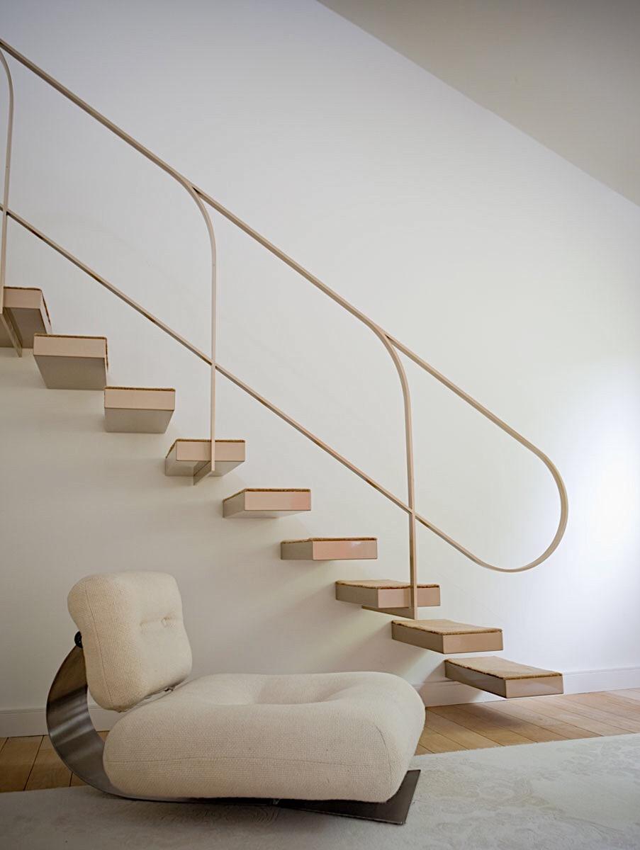 The Rio chaise longue with Niemeyer's cantilevered staircase against a white interior backdrop