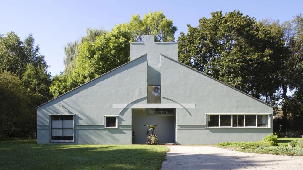 The grey-green façade of the Vanna Venturi House, with its split pediment and arch above the entrance