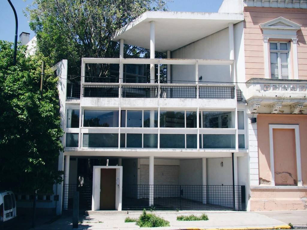 The Curutchet House in La Plata, a white façade on pilotis beside an old mansion