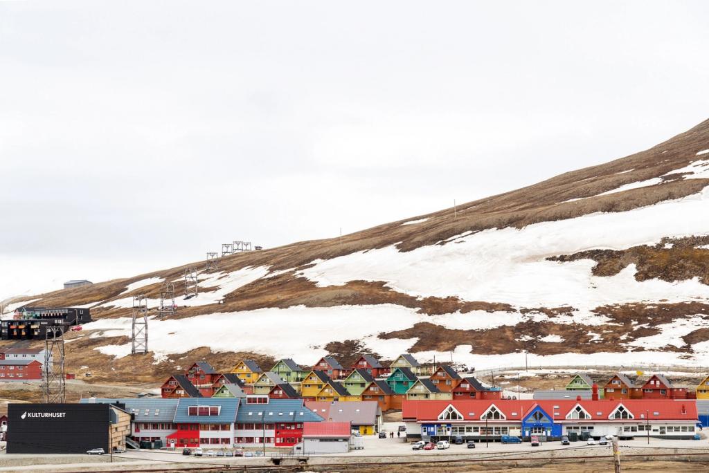 The centre of Longyearbyen with its brightly coloured houses and the Kulturhuset building against a snow-covered slope