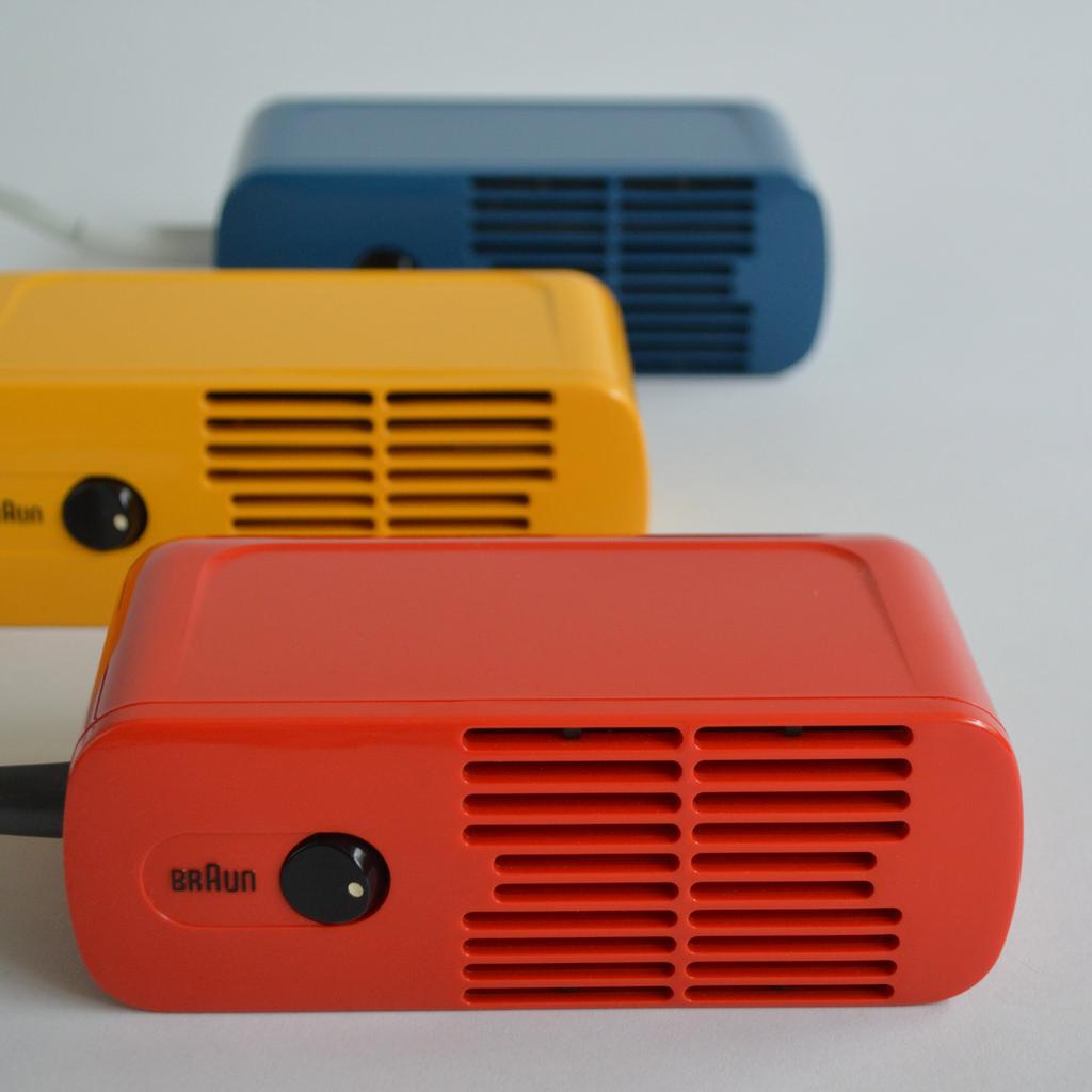 Portable Braun radio with a leather strap, circular speaker and metal tuning knob