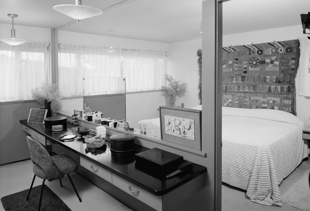 A bedroom in the Gropius House with a built-in dressing table and a woven wall hanging above the bed