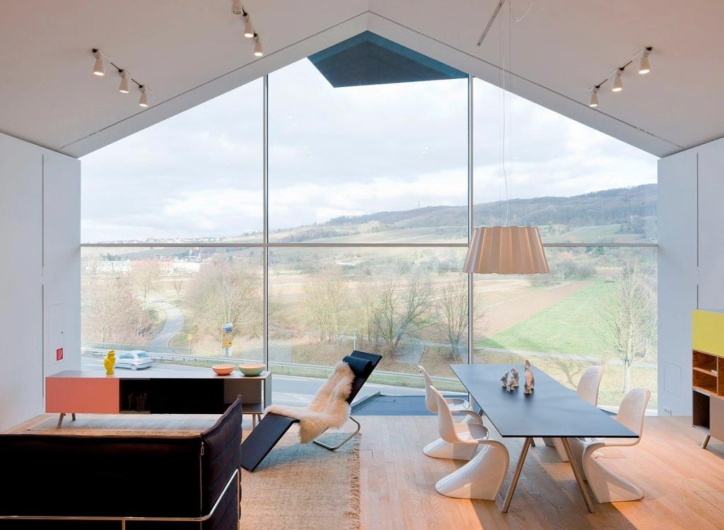 Освещённые стеклянные витрины домиков VitraHaus с мебелью при ночном небе