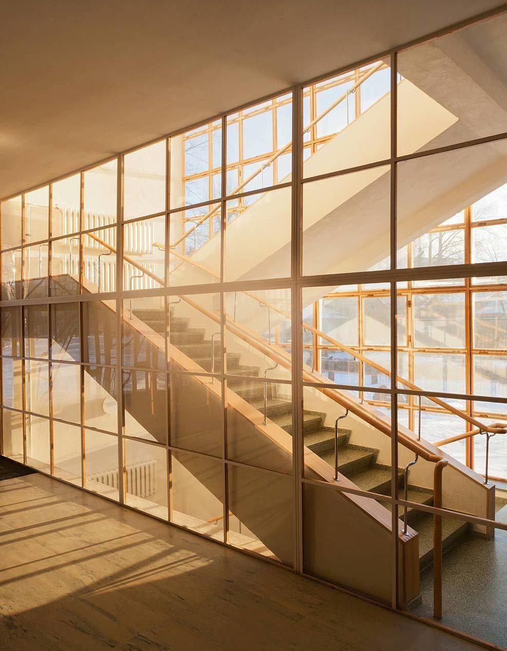Interior of the Viipuri Library, a sun-lit staircase seen through a glazed wooden lattice