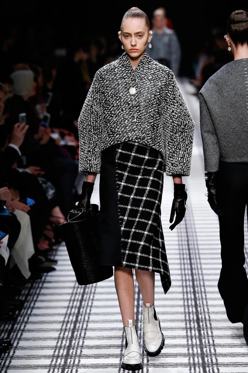 A Balenciaga marl jacket and checked skirt with white shoes on the runway