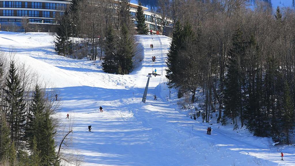 Skiers on the slope at the foot of Kempinski Berchtesgaden in winter