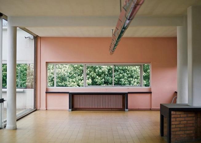 A room at Villa Savoye with pink walls and a ribbon window overlooking the garden