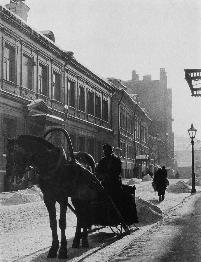 A winter Moscow street with a horse harnessed to a sleigh and a coachman