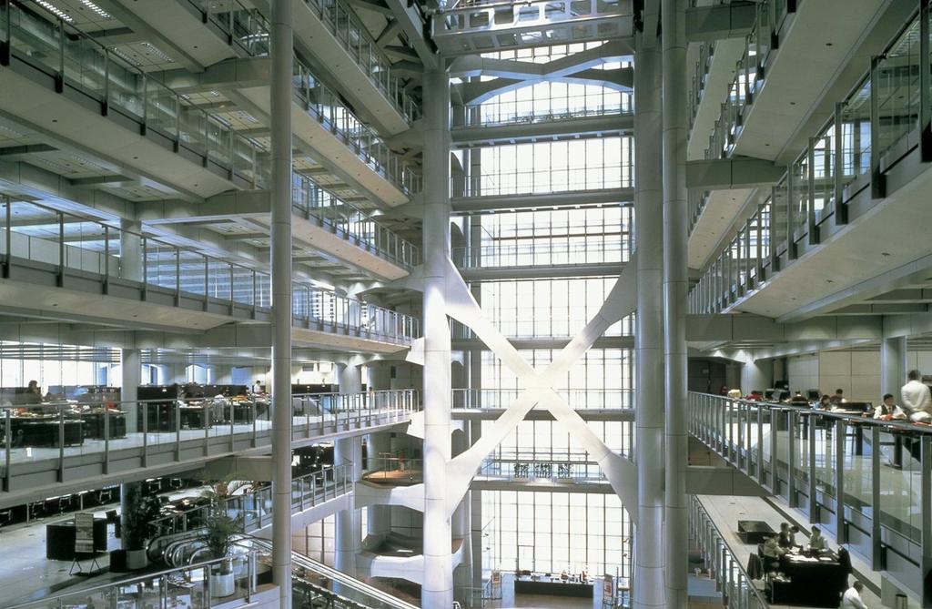 The multi-tiered interior atrium of the HSBC building with a glass wall and a cruciform support
