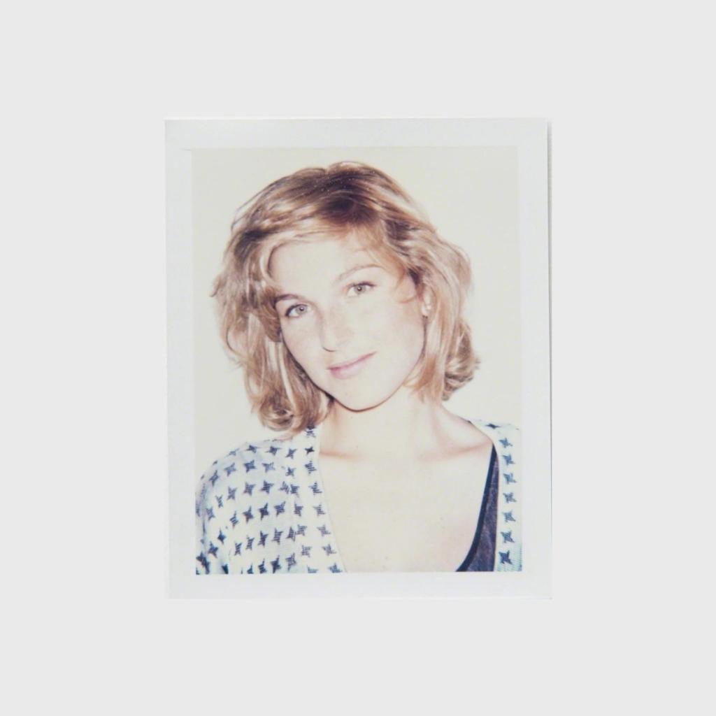 A Polaroid portrait of a young woman with wavy blond hair