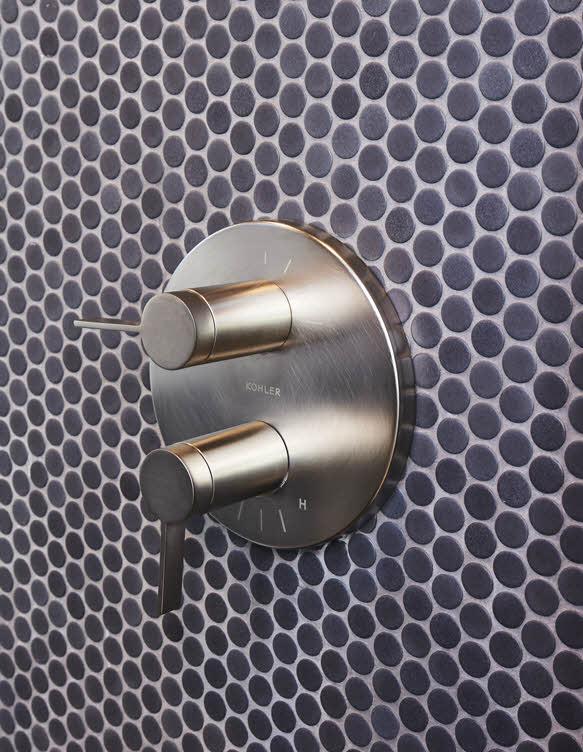 Стальной термостатический смеситель Kohler на стене из тёмной круглой мозаики