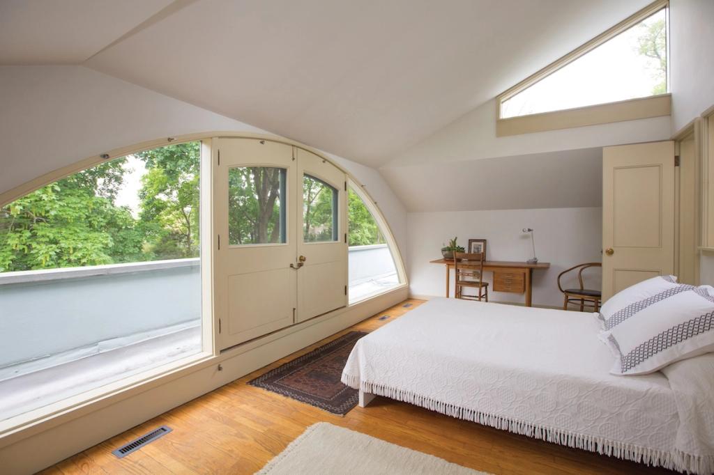 A bedroom in the Vanna Venturi House, with a curved ceiling and an arch over the glazed door