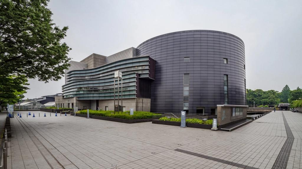The cylindrical dark volume of the Kyoto Concert Hall with its undulating glazed facade