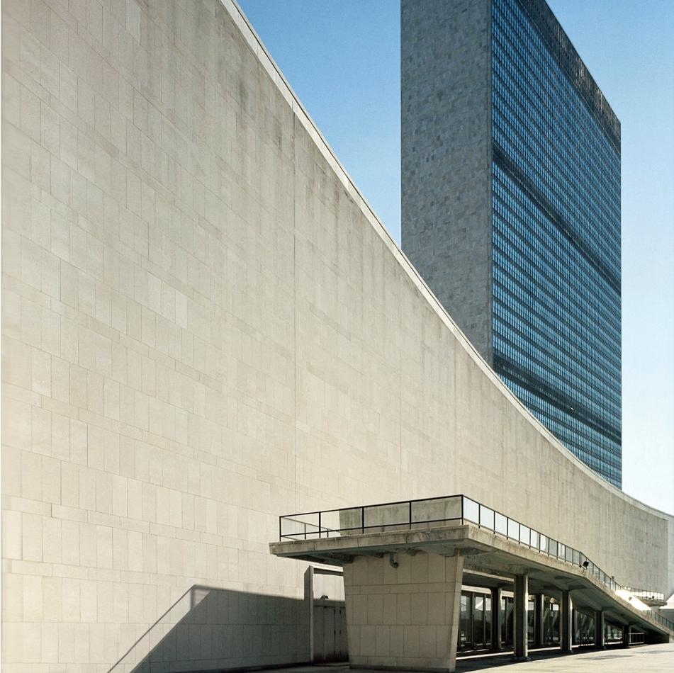 The UN Secretariat building in New York, a curved stone wall and a glass tower