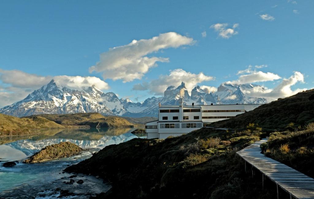 The white Explora Patagonia building beside the lake, with the Torres del Paine massif in the background