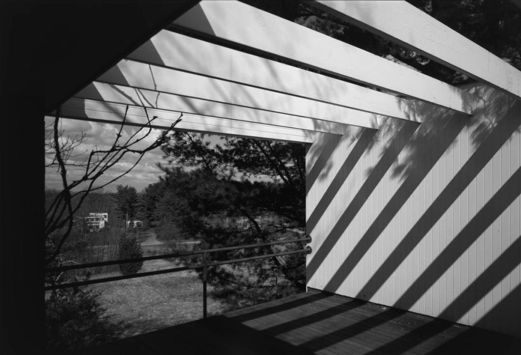 The covered terrace of the Gropius House with exposed beams and a view of a winter landscape
