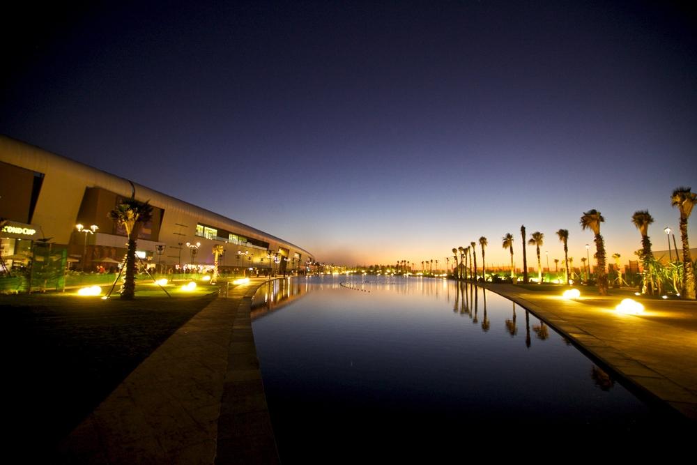 Morocco Mall on the Casablanca waterfront with palm trees and a pool at dusk
