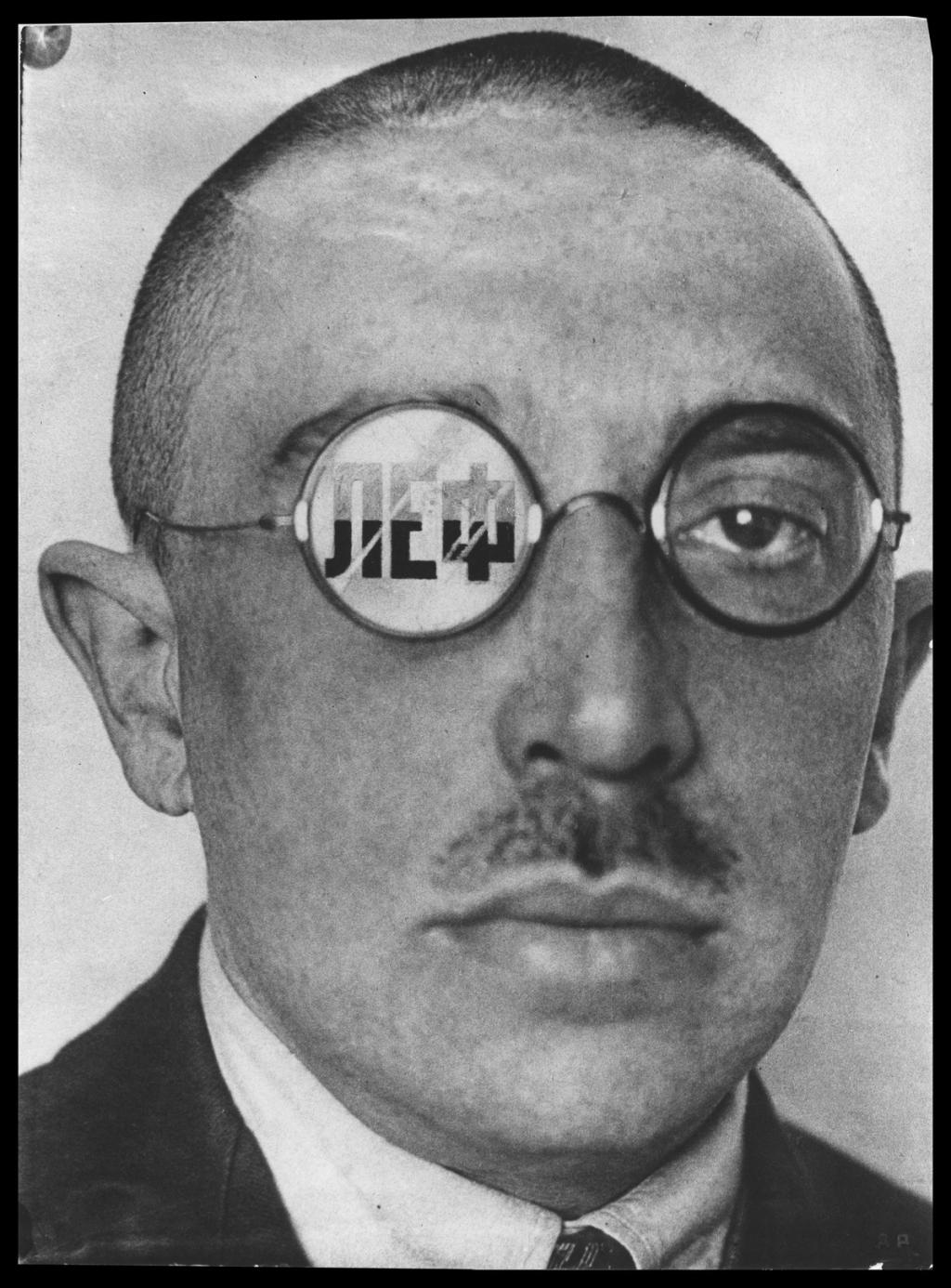 A portrait of Osip Brik with the letters LEF reflected in his spectacle lenses