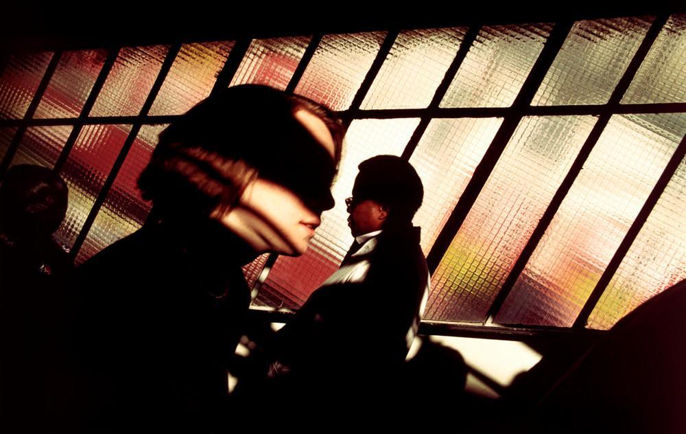 Silhouettes of people against coloured frosted glass in warm backlight