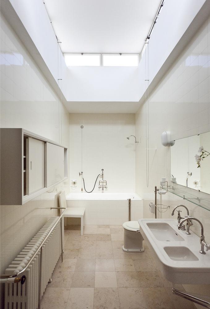 The bright bathroom of Villa Tugendhat with a rooflight, a bathtub and a twin washbasin