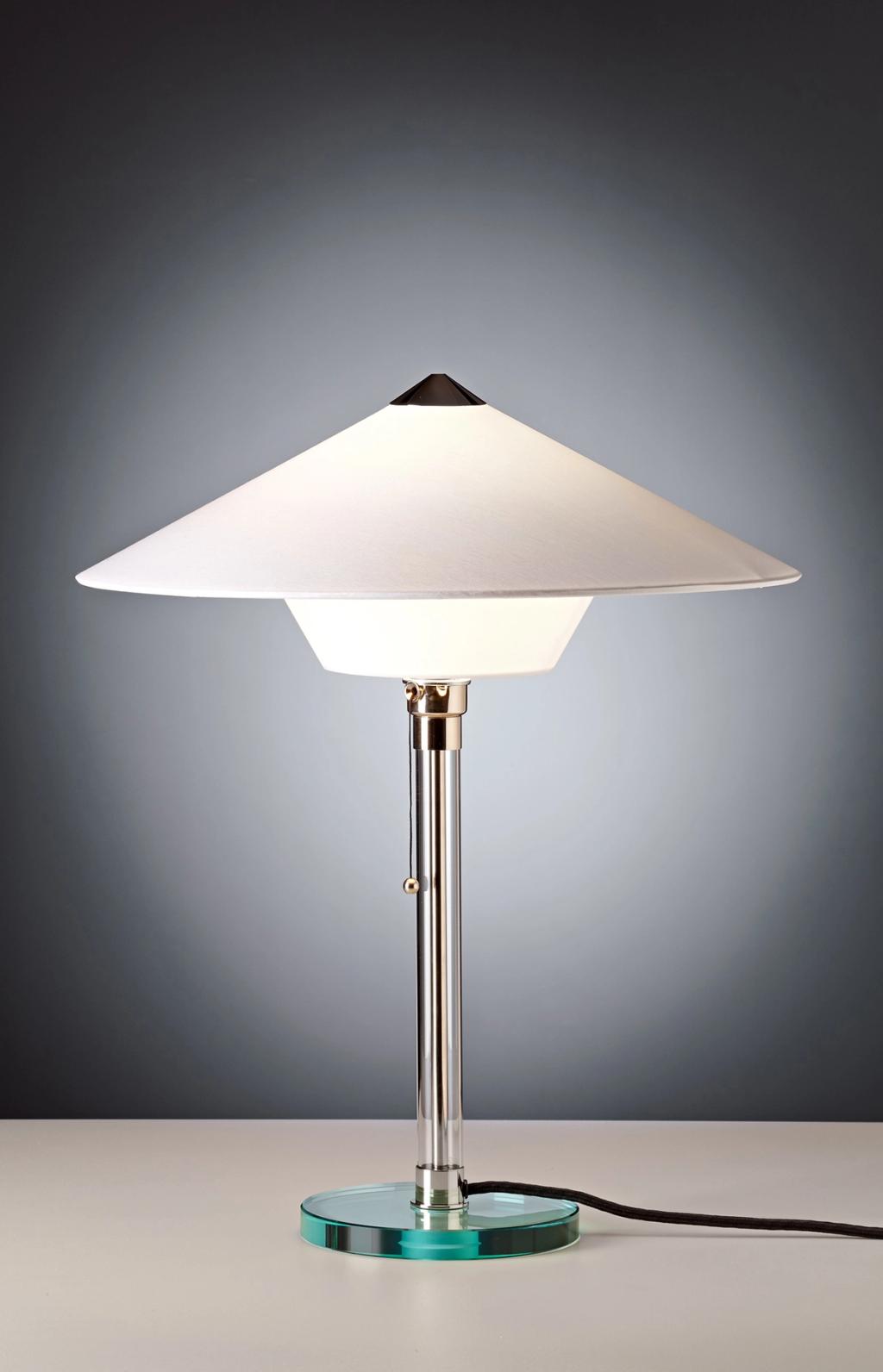 A table lamp with a white conical shade and a glass base