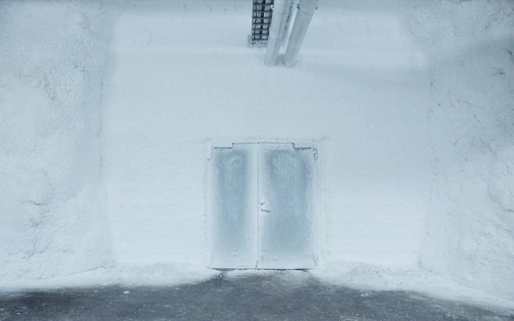 A frost-covered double door to a seed storage chamber in an ice-encrusted room