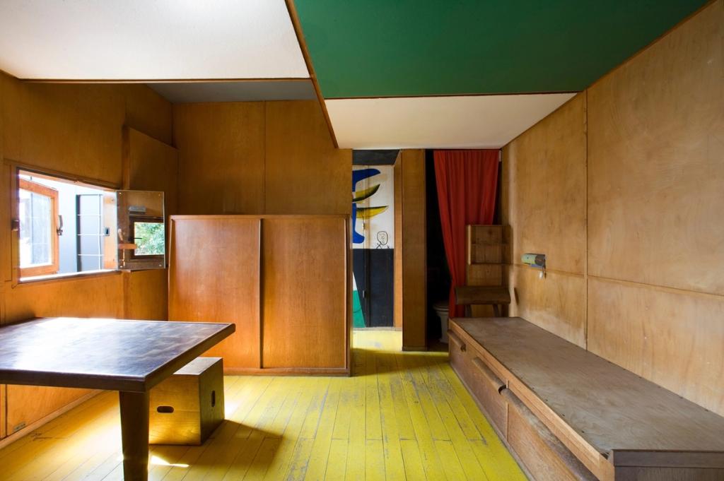 The Cabanon interior with a green ceiling, red curtain and yellow floor