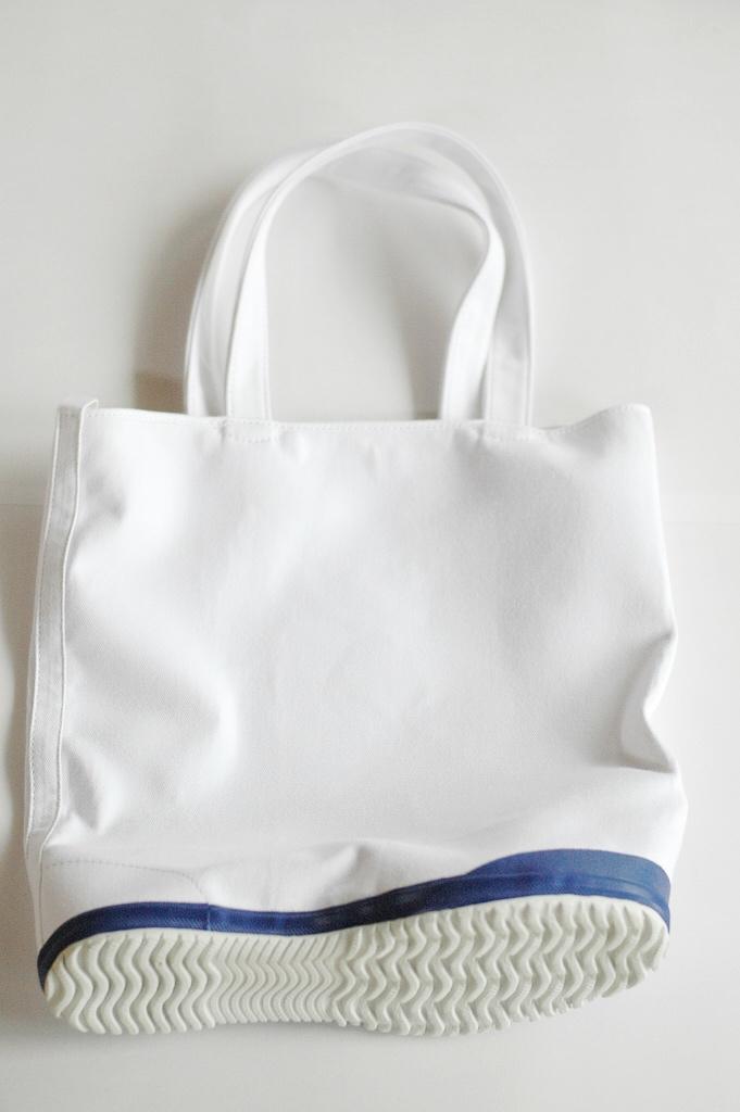 A white canvas tote bag with a trainer sole in place of its base