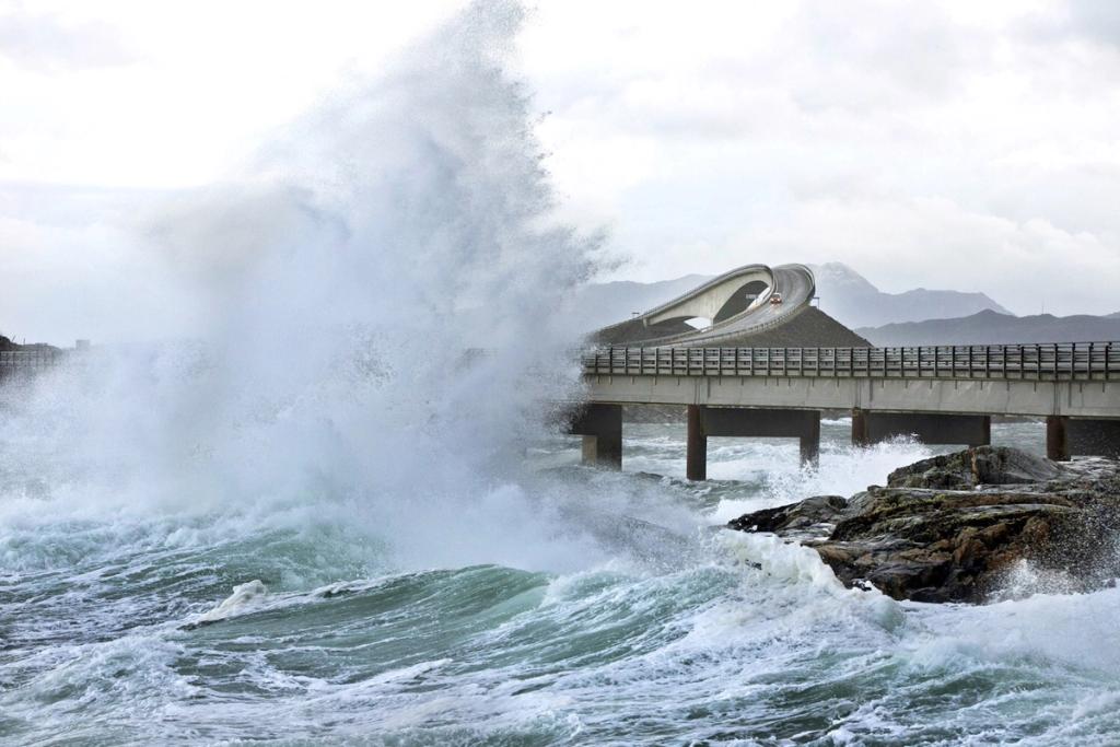 The curved Storseisundet Bridge in a storm, with high waves breaking against its piers