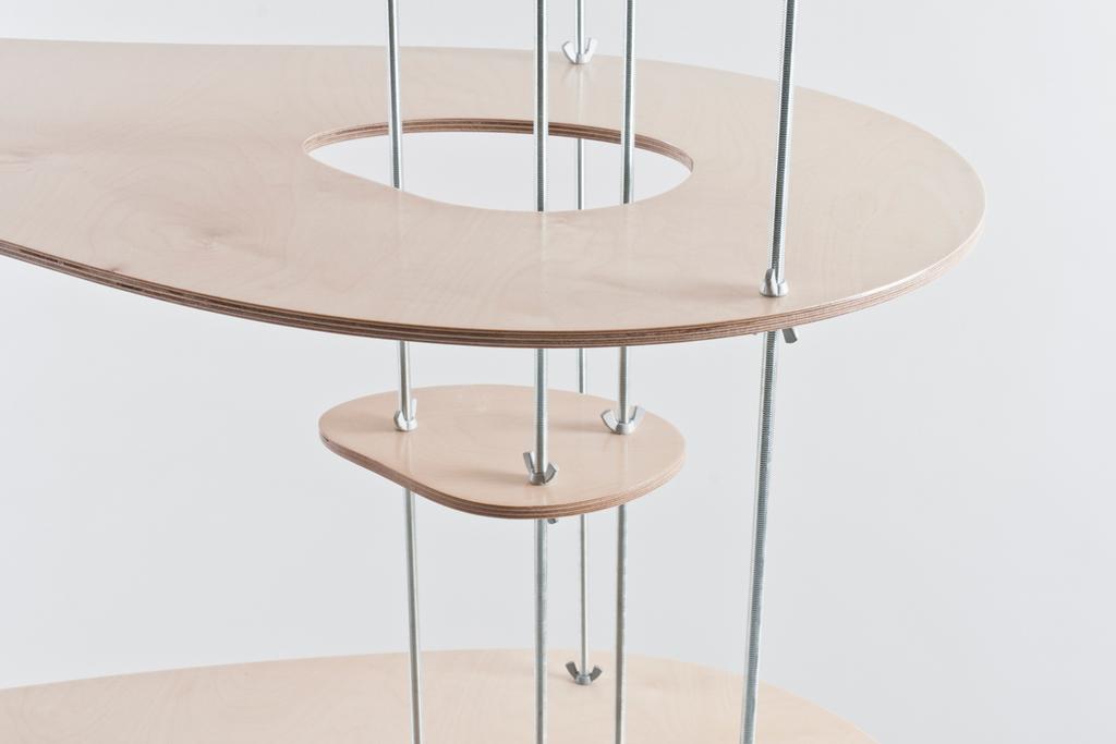 A multi-tiered plywood shelving unit with oval shelves mounted on metal rods, designed by Lyosha Galkin