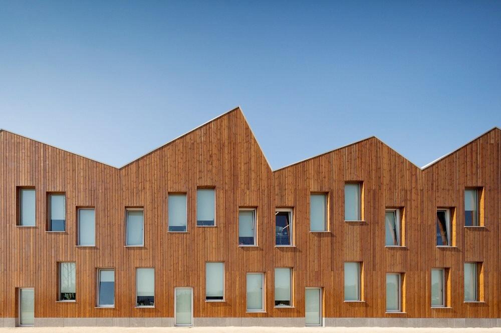 Mouriz school: a timber façade with a jagged sawtooth roof against the sky