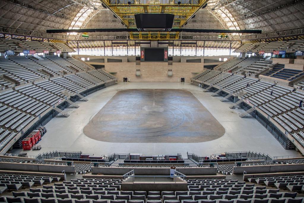 The empty arena of the Palau Sant Jordi, with rows of seating beneath a curved roof