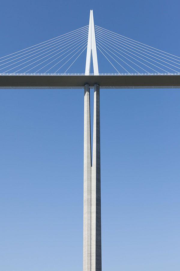 The Millau Viaduct in France: the deck and a V-shaped pylon with stay cables against a blue sky