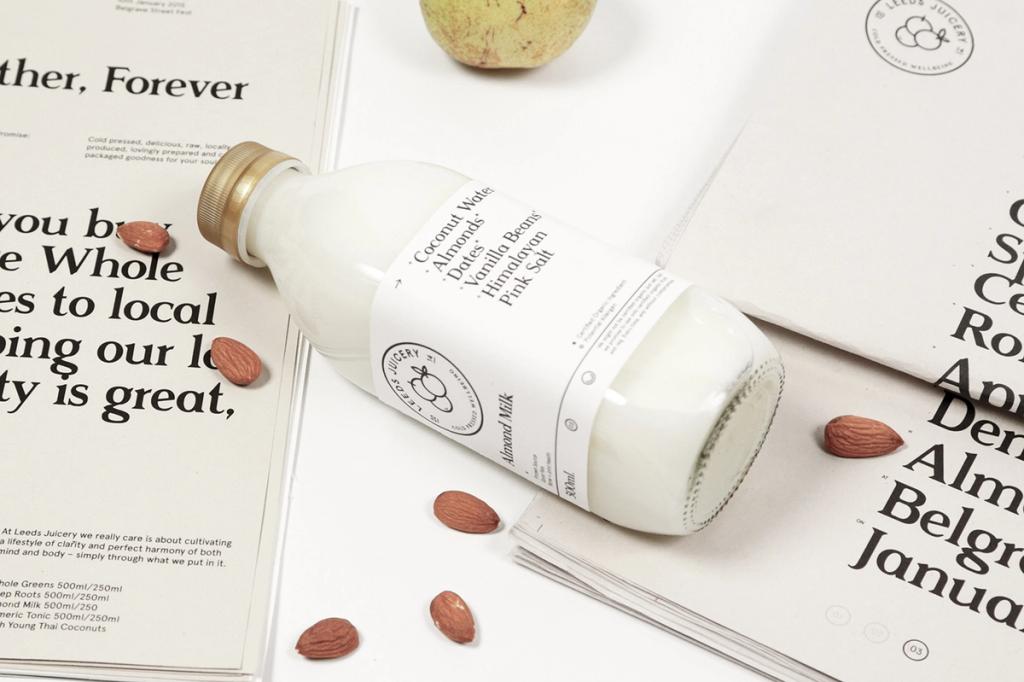 Лежащая бутылка миндального молока Leeds Juicery на печатных листах с миндалём